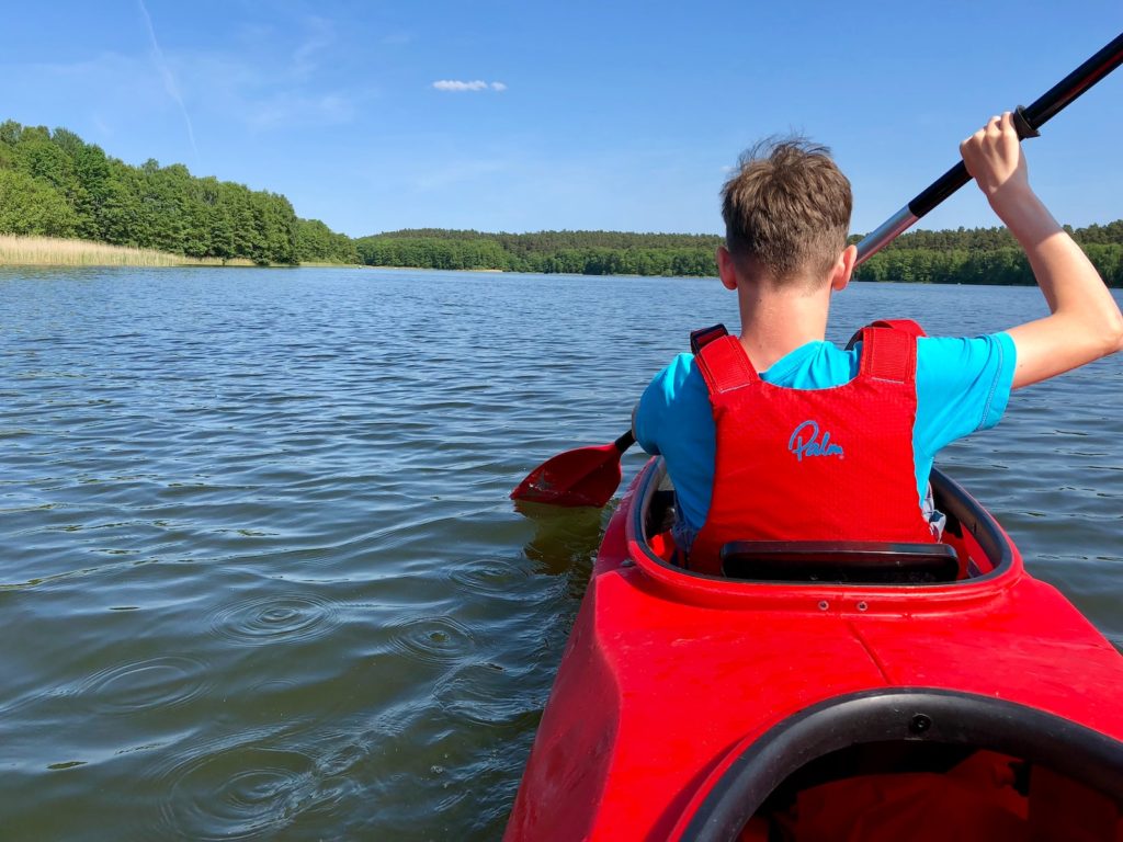 man paddling while riding kayak